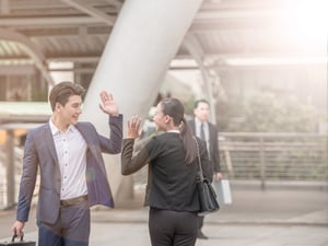 A man and a woman wave goodbye to each other